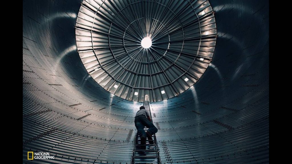 a-man-climbs-to-dizzying-heights-up-a-large-bin-that-is-soon-to-be-filled-with-grain-in-new-raymer-colorado