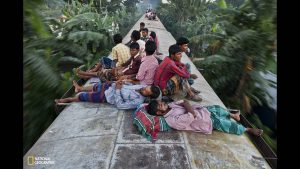 bangladeshis-sleep-on-the-roof-of-a-moving-train-as-they-rush-home-to-their-respective-villages-to-be-with-their-families-in-dhak
