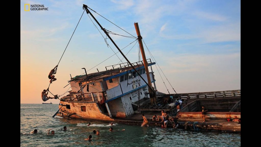 children-in-the-port-paotere-play-near-a-centuries-old-shipwrecked-wooden-boat-pinisi-which-once-explored-the-boundaries-ofmakass