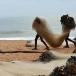 two-young-anglers-in-greater-accra-ghana-carry-fishing-nets-to-their-boat